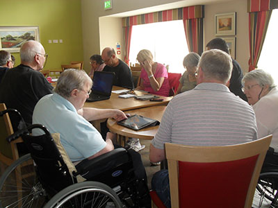 A group of older people learning about tablet computers