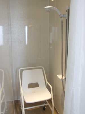 Adapted shower with roll in roll out chair
