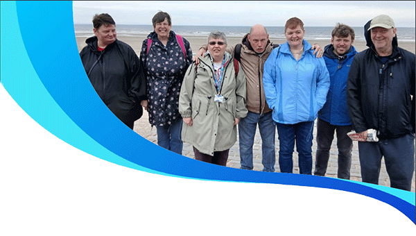  A group of Local Area Co-ordination clients enjoying a windy day together on the beach.